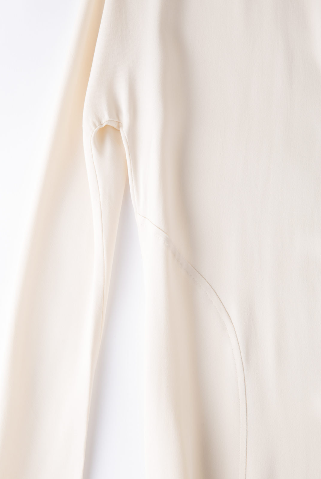 Blouse cream, en tissu double georgette, fluide et féminin, col souple et poignets ouverts, JW Anderson.