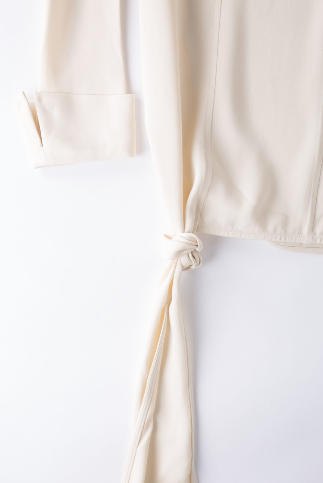 Blouse cream, en tissu double georgette, fluide et féminin, col souple et poignets ouverts, JW Anderson.