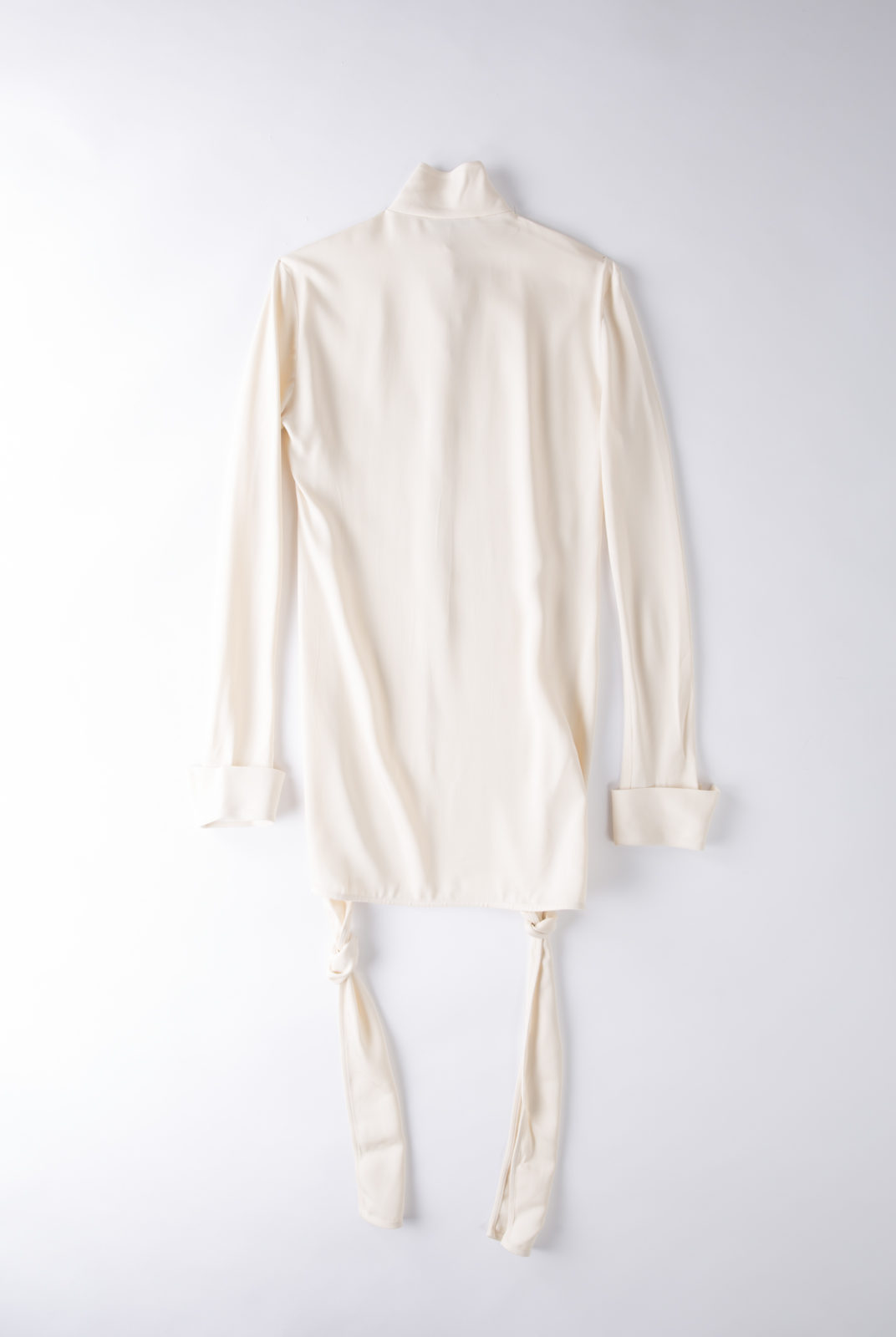 Blouse cream, en tissu double georgette, fluide et féminin, col souple et poignets ouverts, JW Anderson.