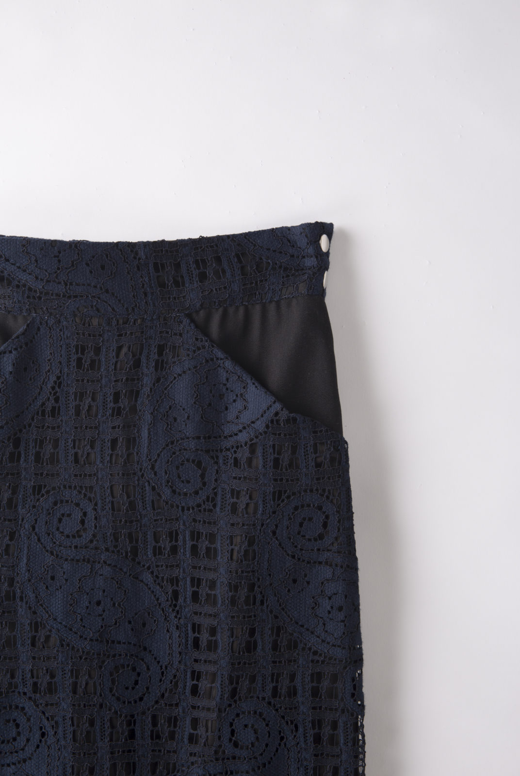 Jupe Lauren réalisée en dentelle de coton mélangé. Coupe droite ajustée. Fente à l'arrière. Fermée par un zop et deux boutons pressions sur le côté.