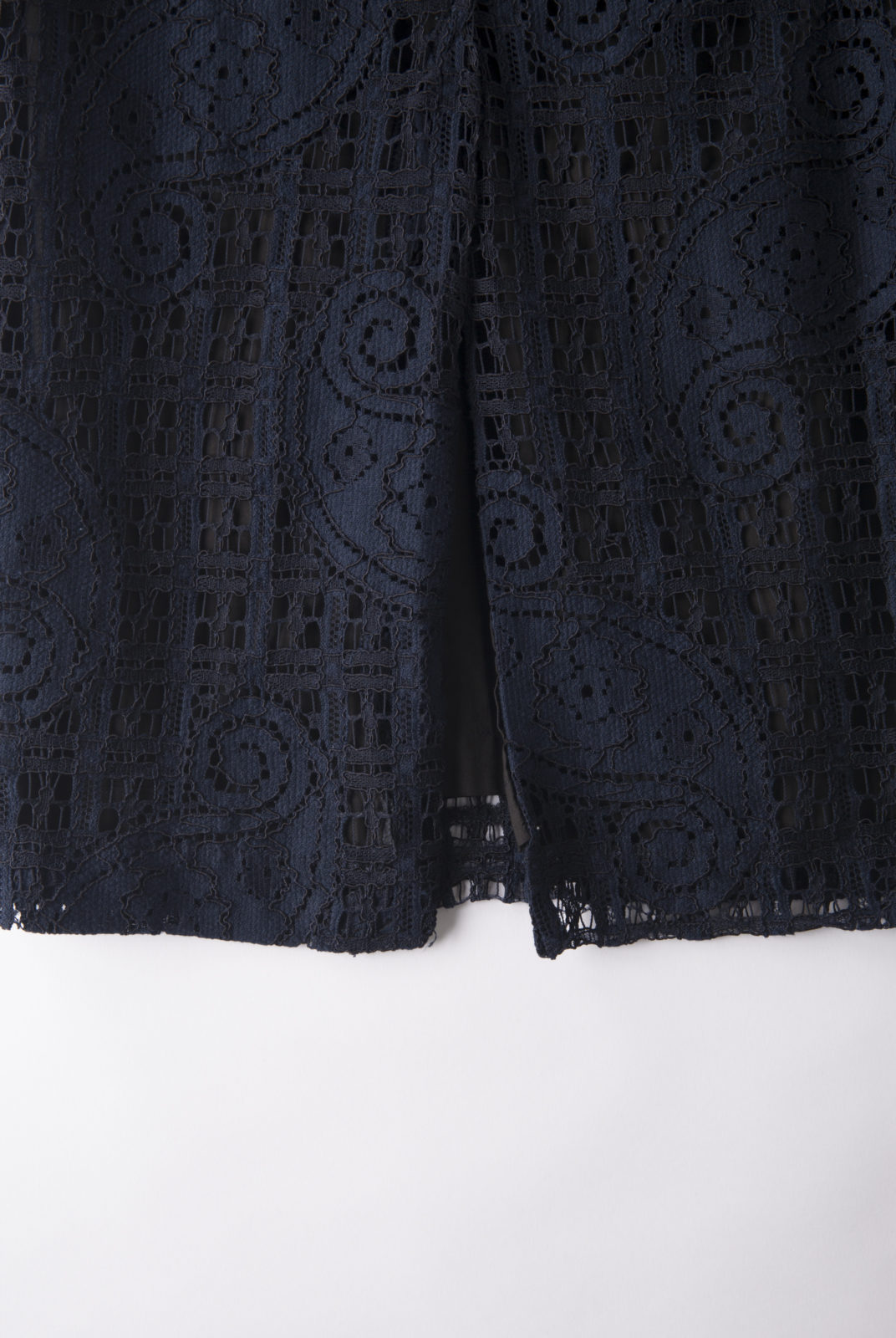 Jupe Lauren réalisée en dentelle de coton mélangé. Coupe droite ajustée. Fente à l'arrière. Fermée par un zop et deux boutons pressions sur le côté.